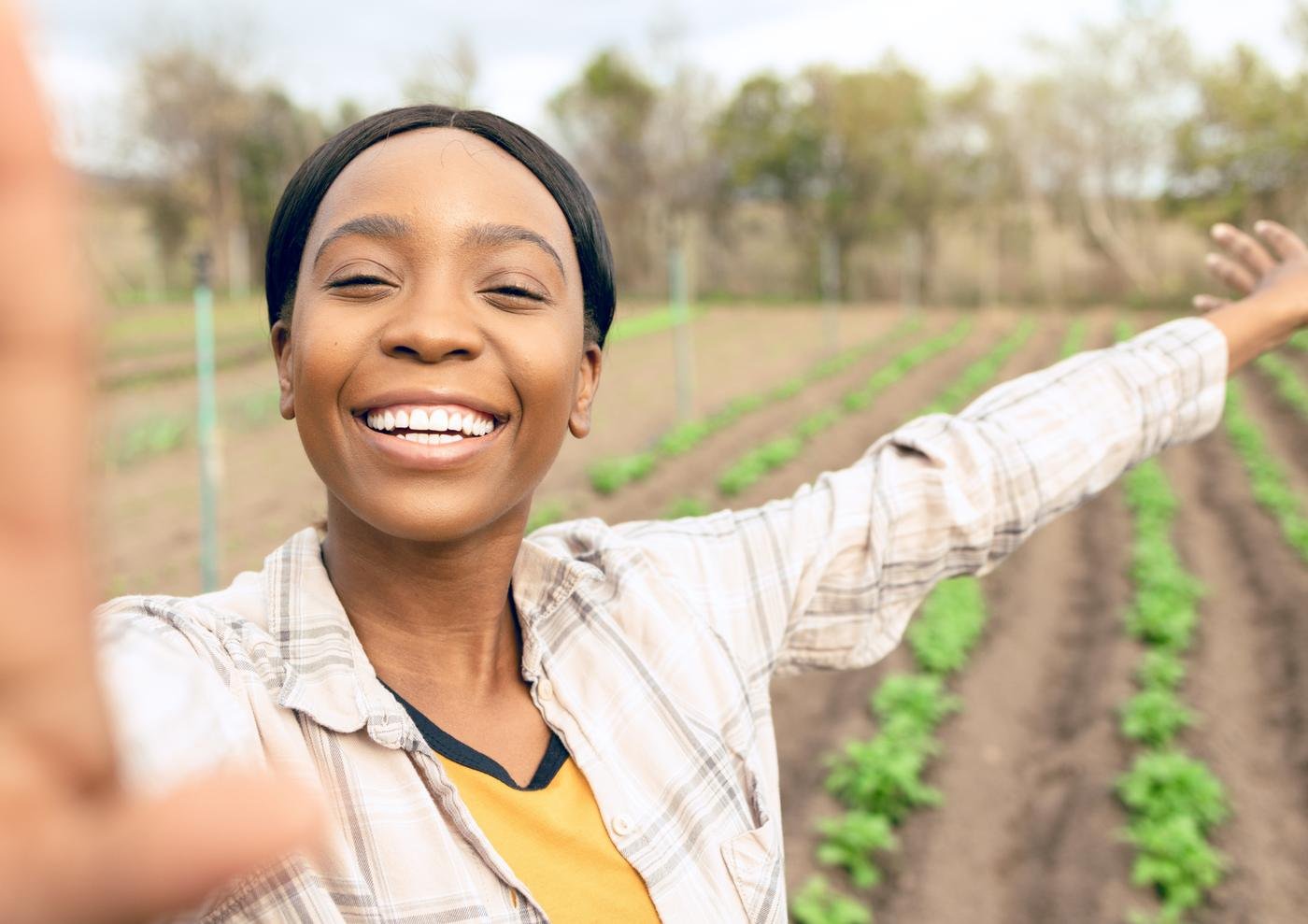 A young woman smiling in a green vegetable field