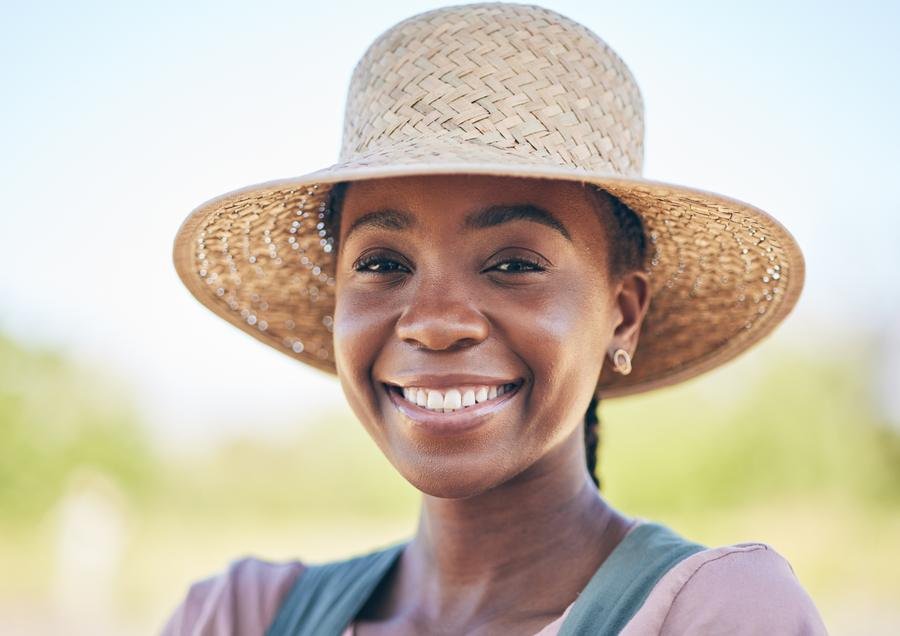 A smiling young farmer in a straw hat